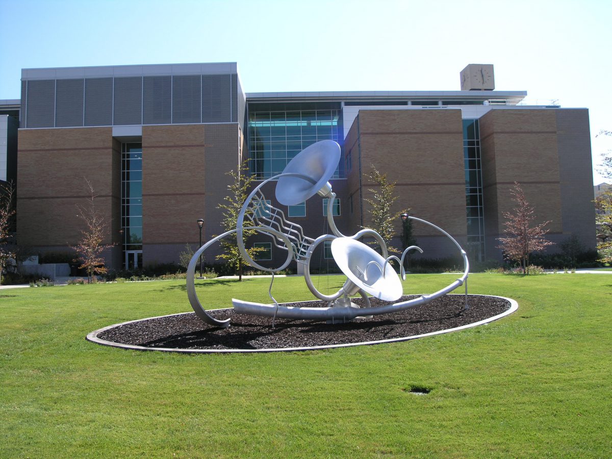 A metal sculpture of horns in a grassy field.