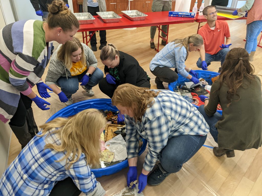 A group of people wearing gloves at a workshop.