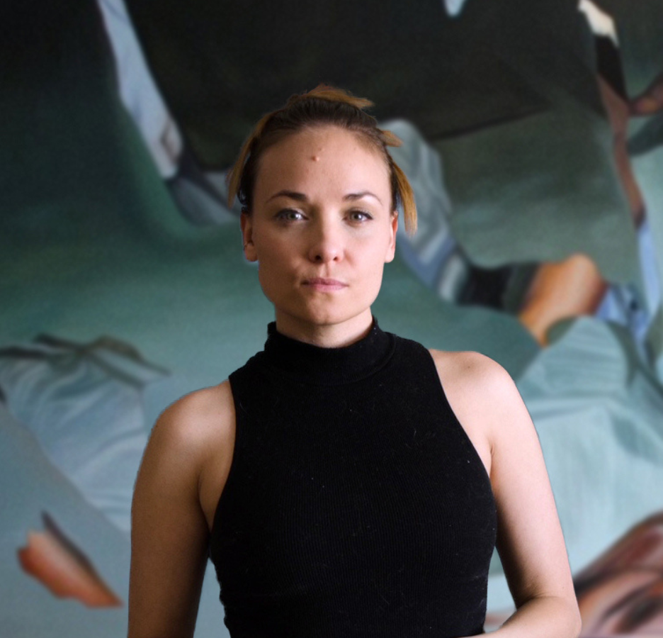A woman in a black sleeveless top stands in front of an artwork.
